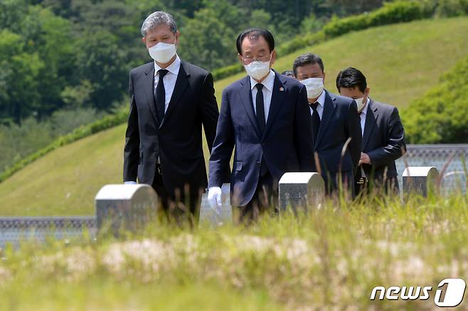 노태우 전 대통령 아들 노재헌씨가 29일 광주 북구 운정동 국립5·18민주묘지에서 헌화·분향을 마친 뒤 김후식 전 5·18부상자회장과 함께 묘역을 둘러보고 있다. 노씨는 참배에 앞서 방명록에 '5·18 광주민주화운동 40주년을 기리며 대한민국 민주화의 씨앗이 된 고귀한 희생에 고개숙여 감사드립니다'라고 적었다. 또 '제13대 대통령 노태우-5·18민주영령을 추모합니다'라고 적힌 조화를 헌화했다. 20205.29 /뉴스1 © News1 한산 기자