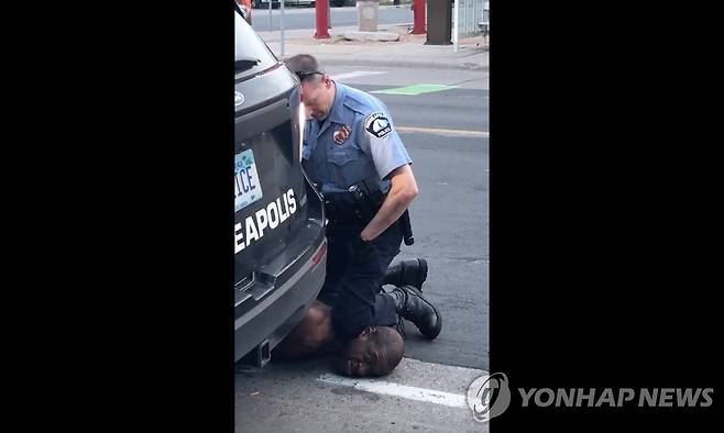 무릎으로 흑인 용의자 목누르는 미국 경찰관 (미니애폴리스 AFP=연합뉴스) 지난 25일(현지시간) 미국 미네소타 주 미니애폴리스에서 경찰이 무릎으로 한 흑인 남성의 목을 누르고 있다. 위조 수표 신고를 받고 출동한 경찰관이 범인으로 의심되는 흑인을 체포하는 장면으로, 당시 현장을 지나가던 행인이 페이스북에 올린 비디오에서 캡처한 사진. 이 흑인은 경찰의 이러한 행위로 결국 숨졌으며 연방수사국(FBI)은 사망 경위 수사에 착수했다. ［재판매 및 DB 금지］ ymarshal@yna.co.kr