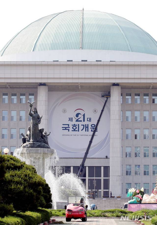 [서울=뉴시스] 김진아 기자 = 21대 국회 개원을 이틀 앞둔 28일 오후 서울 여의도 국회 본청에서 관계자들이 21대 국회 개원을 축하하는 현수막을 설치하고 있다. 2020.05.28.   bluesoda@newsis.com