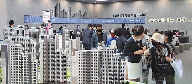 지난달 울산 동구 ‘울산 지웰시티 자이’ 견본 주택을 찾은 관람객들이 주택 모형을 살펴보고 있다. 오는 8월 수도권 비규제지역과 지방광역시로 확대되는 분양권 전매 금지 규제를 앞두고, 이달 전국에서 ‘밀어내기’ 물량이 대거 쏟아질 예정이다. /신영