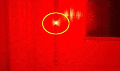 휴대폰에 빨간색 셀로판지로 제작된 '몰래카메라 탐지 카드'를 부착해 몰래카메라를 찾는 모습. 반짝 빛을 내고 있는 게 몰래카메라다. [사진 몰가드]