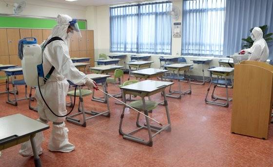 지난달 30일 부산 금정구 한 고교에서 방역 요원들이 교실을 소독하고 있다. 연합뉴스