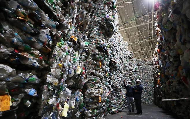 지난달 7일 경기도 화성시의 한 페트(PET) 재활용 업체에서 관계자들이 가득 쌓인 페트 재활용품을 살펴보고 있다.(사진=연합뉴스)