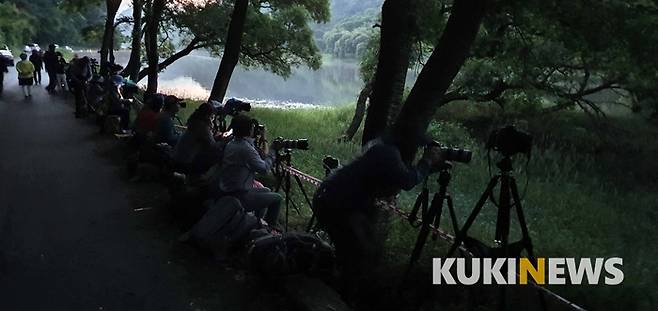 4일 저녁, 충남 금산군 제원면 용화리 마달피 금강변 반딧불이 군락지 앞 도로에서 반딧불이 촬영을 위해 전국에서 온 사진가들이 촬영 준비를 마치고 어두어지기를 기다리고 있다.