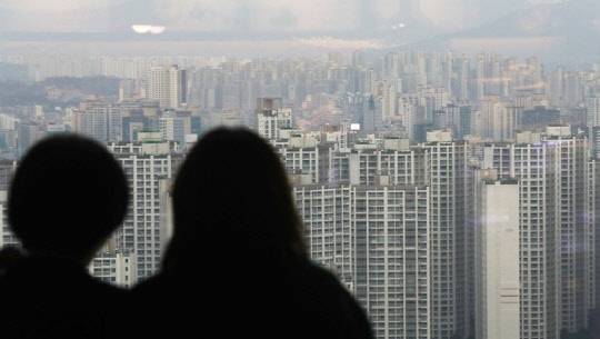 정부가 집값이 좀처럼 진정되지 않자 21번째 추가 규제 대책을 발표한다. 시민들이 잠실 롯데월드타워에서 송파구 일대 아파트 밀집지역을 바라보고 있다.<연합뉴스>