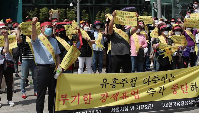 3일 오후 서울시청 앞에서 열린 유흥주점에 대한 서울시 무기한 강제휴업 규탄 기자회견에서 한국유흥음식업중앙회 회원들이 구호를 외치고 있다. 연합뉴스