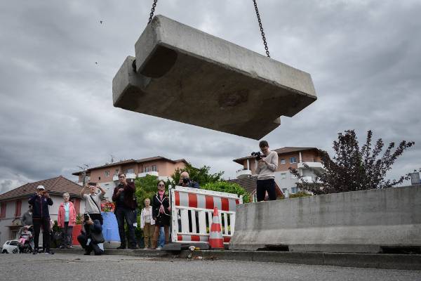 스위스 동부 제네바주 토네에서 14일(현지시간) 프랑스와의 국경을 막고 있던 콘크리트 블록이 철거되는 모습을 주민들이 지켜보고 있다. 코로나19 사태가 진정되면서 스위스 정부는 15일부터 모든 유럽연합(EU) 회원국과 영국, 아이슬란드, 노르웨이, 리히텐슈타인에서 온 관광객의 입국을 허용키로 했다. AFP연합뉴스