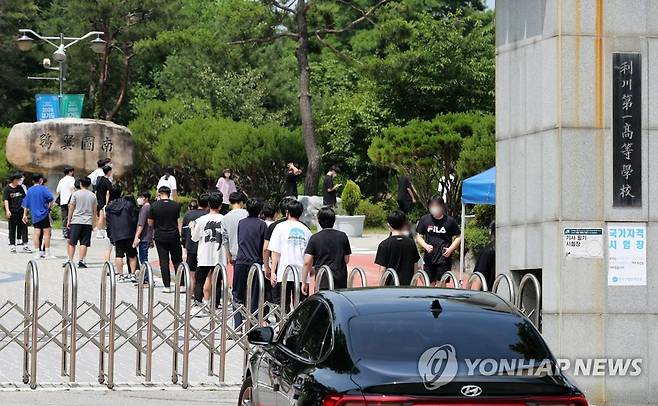 코로나19 전수검사 받는 이천제일고 학생들 (이천=연합뉴스) 권준우 기자 = 교사 1명이 신종 코로나바이러스 감염증(코로나19) 확진 판정을 받은 경기 이천제일고등학교에서 16일 오후 학생들이 코로나19 전수검사를 위해 교문 앞으로 길게 줄서 있다. 2020.6.16 stop@yna.co.kr