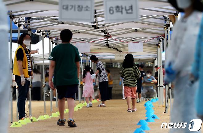 인천 미추홀구에 거주하는 부천 복사골문화센터 어린이집 근무 교직원과 그의 초등학생 딸이 신종 코로나바이러스 감염증(코로나19) 확진 판정을 받은 가운데, 17일 확진자가 발생한 인천시 미추홀구 한 초등학교 정문에 검체 검사를 받으러 온 학생이 검사장에 들어서고 있다. 2020.6.17/뉴스1 © News1 정진욱 기자