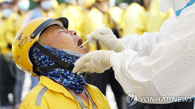 베이징에서 한 메이퇀 음식 배달원이 19일 코로나19 핵산 검사를 받고 있다. [EPA=연합뉴스]