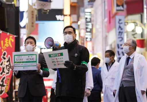 일본 최대 유흥가 가부키초에서 도쿄도 관계자들이 코로나19 확산 방지를 위해 방문 자제를 당부하는 모습/사진=AFP