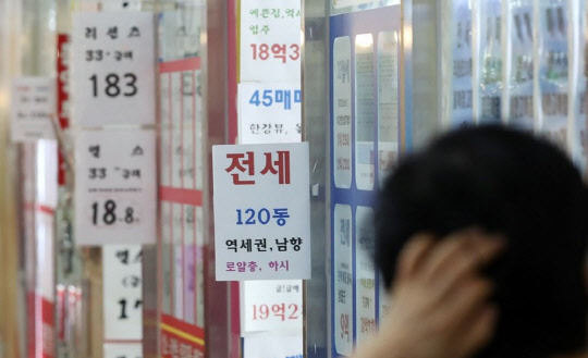 정부의 6·17 대책 발표로 조정대상지역으로 새로 묶인 경기도 일부 지역에서 규제를 풀어달라는 목소리가 거세다. 한 시민이 부동산공인중개업소에 걸린 아파트 급매물 시세를 살펴보고 있다.<연합뉴스>