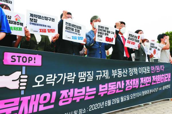 참여연대 관계자들이 29일 서울 종로구 청와대 앞 분수대광장에서 ‘문재인정부 부동산 정책 전면 전환 촉구’ 기자회견을 열고 보유세 실효세율 강화와 공시가격 현실화, 다주택자 양도소득세 강화 등 7대 요구안을 발표한 뒤 구호를 외치고 있다. 연합뉴스