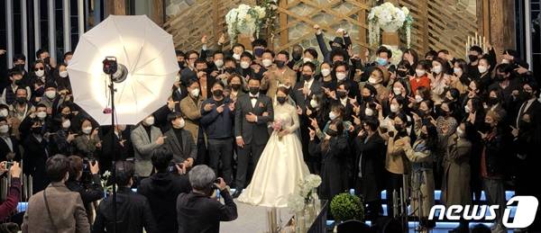 서울 마포구 한 예식장에서 마스크를 쓴 신랑 신부와 하객들이 기념사진을 찍고 있다. / 사진=뉴스1