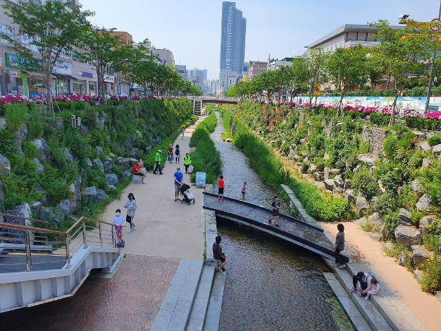 지난 7일 오후 무더위를 피해 심곡천을 찾은 아이들이 물놀이를 하고, 어른들은 산책을 하며 즐기고있다. 임명수 기자