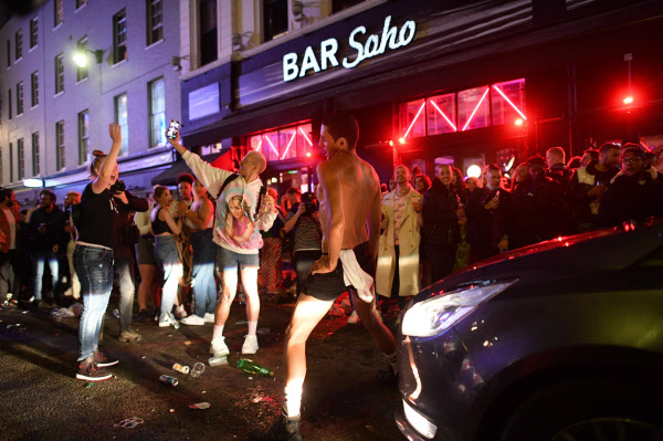 4일(현지 시각) 영국 런던 소호 거리에서 술에 취한 시민들이 차량 통행을 막아선 채 춤을 추고 영상을 찍어대고 있다. /AFP 연합뉴스