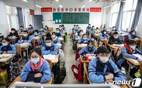(AFP=뉴스1) 송원영 기자 = 30일 중국 장쑤성 화이안 한 학교 교실에서 신종 코로나바이러스 감염증(코로나19) 여파로 개학이 연기됐던 고등학교 3학년과 중학교 3학년 학생들이 마스크를 쓰고 수업을 받고 있다.  ⓒ AFP=뉴스1