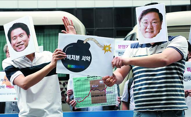 경제정의실천시민연합(경실련)은 7일 오전 서울 여의도 더불어민주당사 앞에서 기자회견을 열고 민주당 의원들이 4·15 총선 전 다주택을 처분하겠다고 약속해놓고 지키지 않는 행태를 비판했다. 경실련 관계자들이 민주당 이인영(왼쪽) 전 원내대표와 김태년 원내대표의 얼굴 사진 가면을 쓰고 두 사람이 다주택 처분 서약 이행을 ‘폭탄 돌리기’ 하듯 서로 미루는 모습을 보여주는 퍼포먼스를 하고 있다. /남강호 기자