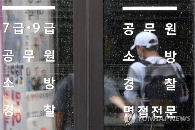 코로나, 고시학원까지 확산 (광주=연합뉴스) 정회성 기자 = 지난 8일 오전 광주 동구 대의동 고시학원 밀집가에서 마스크를 착용한 공무원 시험 준비생이 걸어가고 있다. 인근에 자리한 광주고시학원에서는 최근 다수 수강생이 코로나19 확진 판정을 받았다. 2020.7.8 hs@yna.co.kr