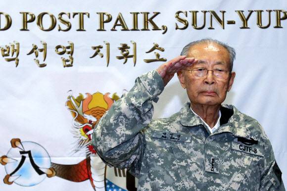 1920년 평남 강서에서 출생한 백선엽 장군은 6·25 전쟁 당시 낙동강 전투와 38선 돌파 작전 등 결정적인 전투를 지휘했으며 그 공로를 인정받아 1953년 한국군 최초로 대장으로 진급했다. 사진은 2013년 8월 경기 파주시 뉴멕시코 사격장에서 열린 백선엽 장군 미8군 명예사령관 임명식에서 미군 야전상의를 입은 뒤 경례하는 백 장군. 연합뉴스　