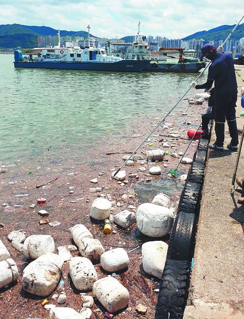 해양환경공단 마산지사 직원들이 해양부유쓰레기 수거 전용 선박인 ‘청항선’이 닿지 못하는 곳에서 갈퀴를 이용해 해양 부유 쓰레기를 수거하고 있다.