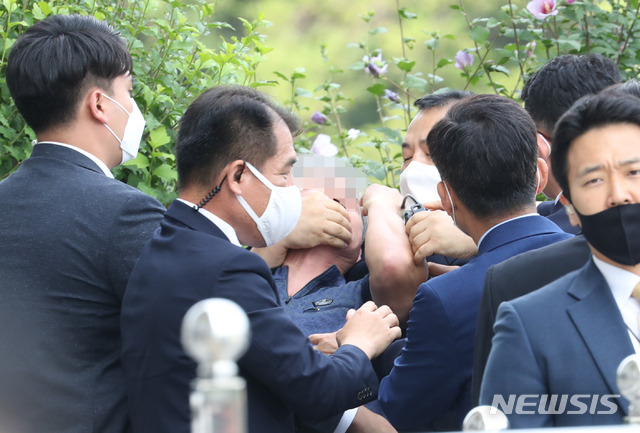 [서울=뉴시스]박영태 기자 = 16일 오후 서울 여의도 국회에서 열린 제21대 국회 개원식에 참석해 개원 축하 연설을 마친 문재인 대통령을 향해 신발을 던지고 돌발 발언을 한 시민의 입을 경호원들이 막고 있다. 2020.07.16. since1999@newsis.com