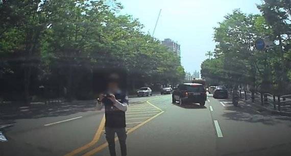 구급차를 가로막은 택시기사 최모씨가 사진을 찍는 모습. 블랙박스 캡처.