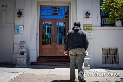 23일(현지시간) 미 샌프란시스코의 중국 영사관 앞에서 한 남성이 담배를 피우고 있다. [AFP=연합뉴스]