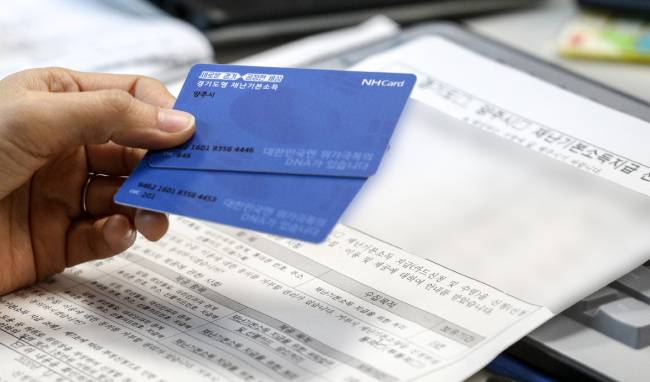 경기도가 1인당 10만원씩 지급하는 재난기본소득에 대한 현장 신청이 시작된 4월20일 경기 양주시 양주2동 주민센터에 마련된 접수 창구에서 시민이 선불카드를 신청하고 있다. / 사진=뉴스1