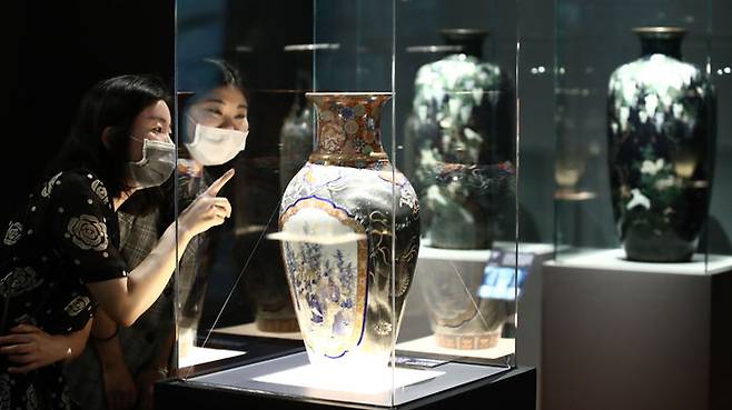 전시 관계자들이 일본, 중국 등에서 온 수입 화병 등 전시물을 관람하고 있다.