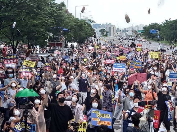 1일 서울 영등포구 여의도동 여의도공원 인근에서 열린 두번째 전국민 조세저항 국민집회에서 6.17 규제 소급적용 피해자 구제를 위한 모임 등 참석자들이 정부의 부동산 정책을 규탄하며 신발을 던지는 퍼포먼스를 하고 있다.