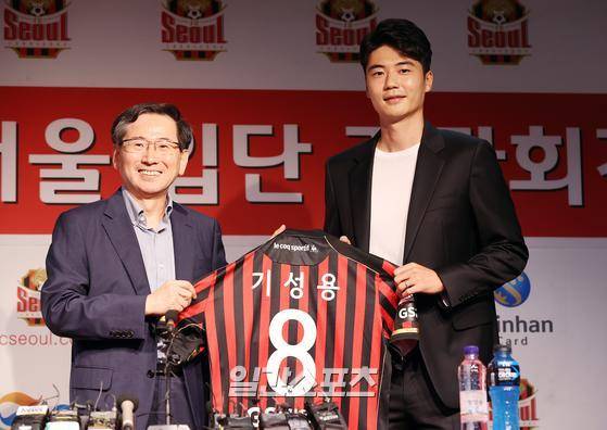 지난달 21일 서울월드컵경기장에서 열린 입단 기자회견에서 기성용이 엄태진 GS스포츠 사장으로부터 유니폼을 전달받고 포즈를 취하고 있다. 김민규 기자