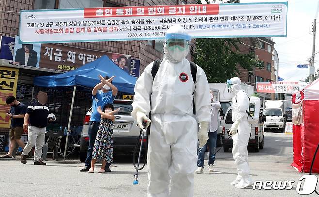 16일 오후 신종 코로나바이러스 감염증(코로나19) 확진자가 집단발병한 서울 성북구 사랑제일교회 앞에서 구청 관계자들이 방역작업을 펼치고 있다. 중앙방역대책본부는 이날 낮 12시 기준 사랑제일교회와 관련한 코로나19 누적 확진자가 총 249명이라고 밝혔다. 전날 낮 12시 59명에 비해 190명이 증가한 수치이다. 2020.8.16/뉴스1 © News1 황기선 기자