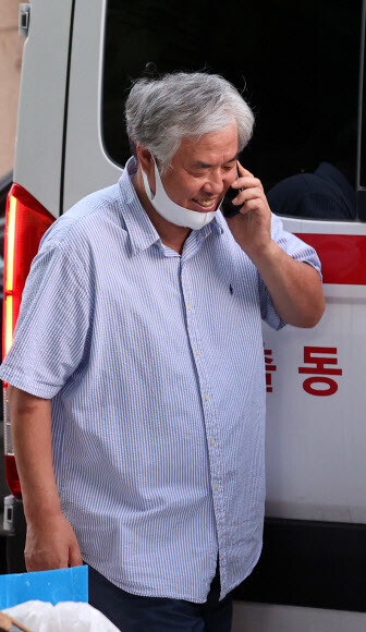 17일 코로나19 확진 판정을 받은 전광훈 목사가 성북구보건소 차량으로 이동하며 마스크를 내리고 전화통화를 하고 있다. 연합뉴스