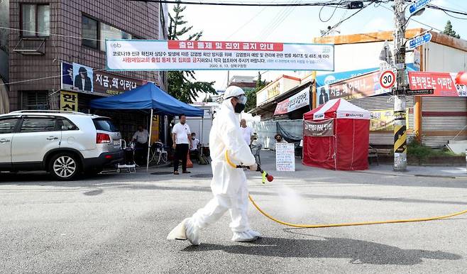 장위동 상인, 주민, 공무원 등이 18일 오후 서울 성북구 장위2동 사랑제일교회 인근 도로에서 합동 방역을 하고 있다 / 사진=뉴시스