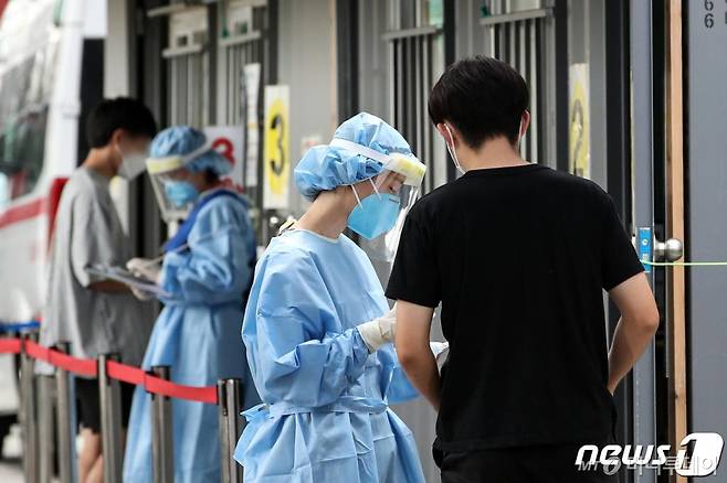 신종 코로나바이러스 감염증(코로나19) 확산세가 이어지고 있는 20일 오후 서울 성북구보건소에 마련된 선별진료소를 찾은 시민들이 검사를 위해 의료진의 설명을 듣고 있다./사진=뉴스1