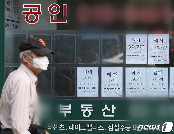 공인중개업소 앞을 마스크를 쓴 주민이 지나고 있다.© News1 김진환 기자