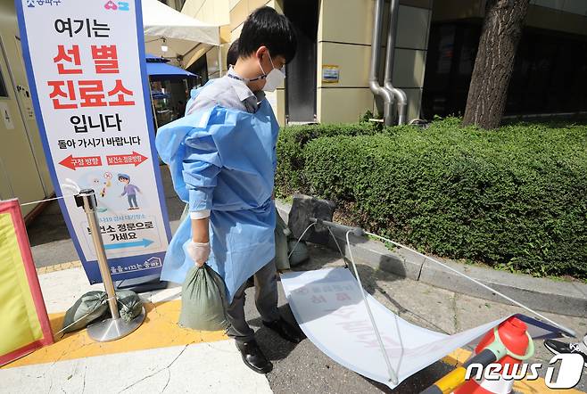 제8호 태풍 '바비'(Bavi)가 북상중인 26일 서울 송파구보건소에 설치된 신종 코로나바이러스 감염증(코로나19) 선별진료소에서 직원들이 강풍에 대비해 시설물을 모래주머니로 고정하고 있다. 2020.8.26/뉴스1 © News1 허경 기자