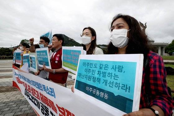 전국 이주인권 단체 회원들이 지난 6월 30일 오전 서울 종로구 청와대 분수대 앞에서 열린 '코로나 사태 장기화 속에 차별로 고통받는 이주민들의 목소리, 차별과 배제가 아니라 생존과 체류를 보장하라' 기자회견에 참석해 구호를 외치고 있다. 뉴시스.