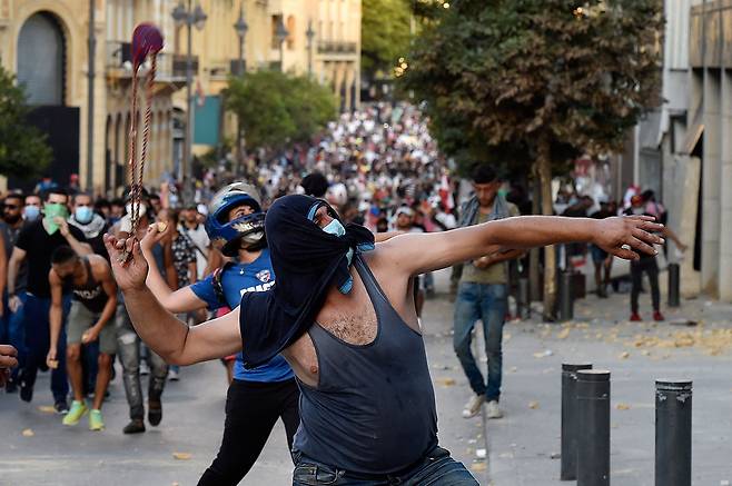 ⓒAFP PHOTO8월11일 폭발 참사에 대한 정부의 책임을 묻는 시위대가 돌을 던지고 있다.