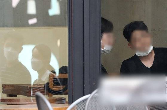 서울 전역에서 실내·외 마스크 착용 의무화가 시작된 지난 24일 마스크를 턱에 걸치고 대화하는 사람들. [뉴스1]