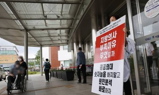 정부의 보건의료정책에 반대하는 대한의사협회의 집단휴진 이틀째인 지난 27일 서울 종로구 서울대학교병원에서 전문의가 피켓 시위를 이어가고 있는 모습. 연합뉴스