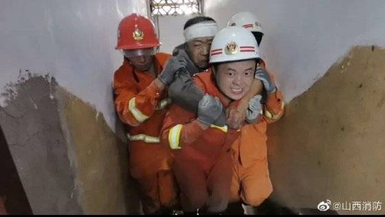 중국 소방대원이 산시성 린펀시 쥐시엔 식당 붕괴 현장에서 매몰자를 구출해 밖으로 나오고 있다. 57명 매몰자 중 29명이 숨지고 7명 중상, 21명이 경상을 입었다. [중국 인민망 캡처]