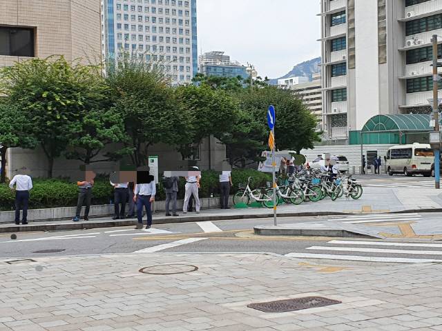 28일 서울 종로구 광화문 인근 ‘따릉이’ 정거장 앞에서 흡연자들이 담배를 피우고 있다./심기문기자