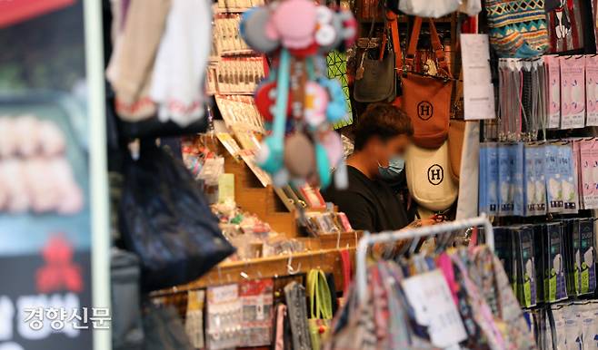 명동의 한 잡화점에 상인이 마스크를 쓰고 앉아 있다. / 권도현 기자