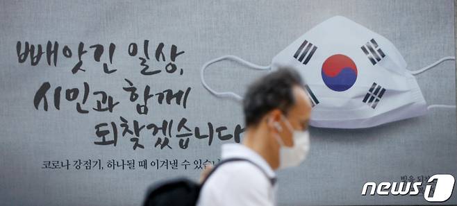 2일 서울광장에서 시민들이 출근길을 서두르고 있다. 서울도서관 외벽에 '빼앗긴 일상, 시민과 함께 되찾겠습니다', '코로나 강점기, 하나될 때 이겨낼 수 있습니다'라는 문구와 태극기가 새겨진 마스크 그림의 꿈새김판이 눈에띈다. 2020.9.2/뉴스1 © News1 안은나 기자
