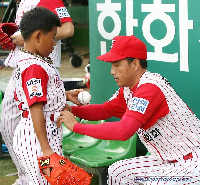 2006년 8월 22일 한화와 두산의 경기에서 경기 시작 전 송진우가 아들 송우현의 옷을 고쳐주고 있다.