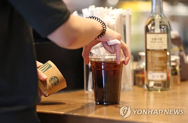 프랜차이즈 카페는 포장만 (서울=연합뉴스) 류영석 기자 = 사회적 거리두기 2.5단계가 시행되고 있는 가운데 지난달 31일 오후 서울 성동구의 한 프랜차이즈형 커피전문점을 찾은 시민이 포장주문한 커피를 받고 있다. 2020.8.31 ondol@yna.co.kr