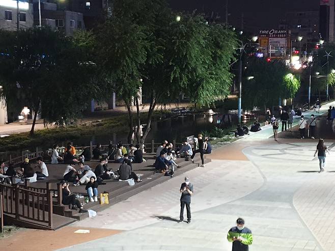 4일 자정쯤 도림천변에 있는 벤치에 사람들이 돗자리를 깔고 삼삼오오 모여있다. /김영준 기자