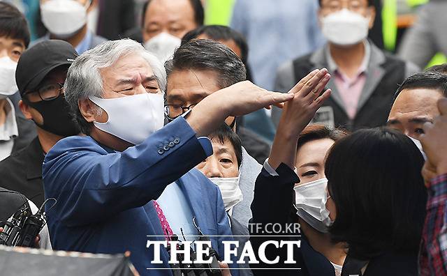 전광훈 사랑제일교회 목사가 7일 오후 서울 성북구 사랑제일교회 인근 자택에서 나와 구치소로 이동하며 파라솔과 우산으로 취재진의 시야를 가린 신도들에게 치우라는 손짓을 하고 있다. /이새롬 기자